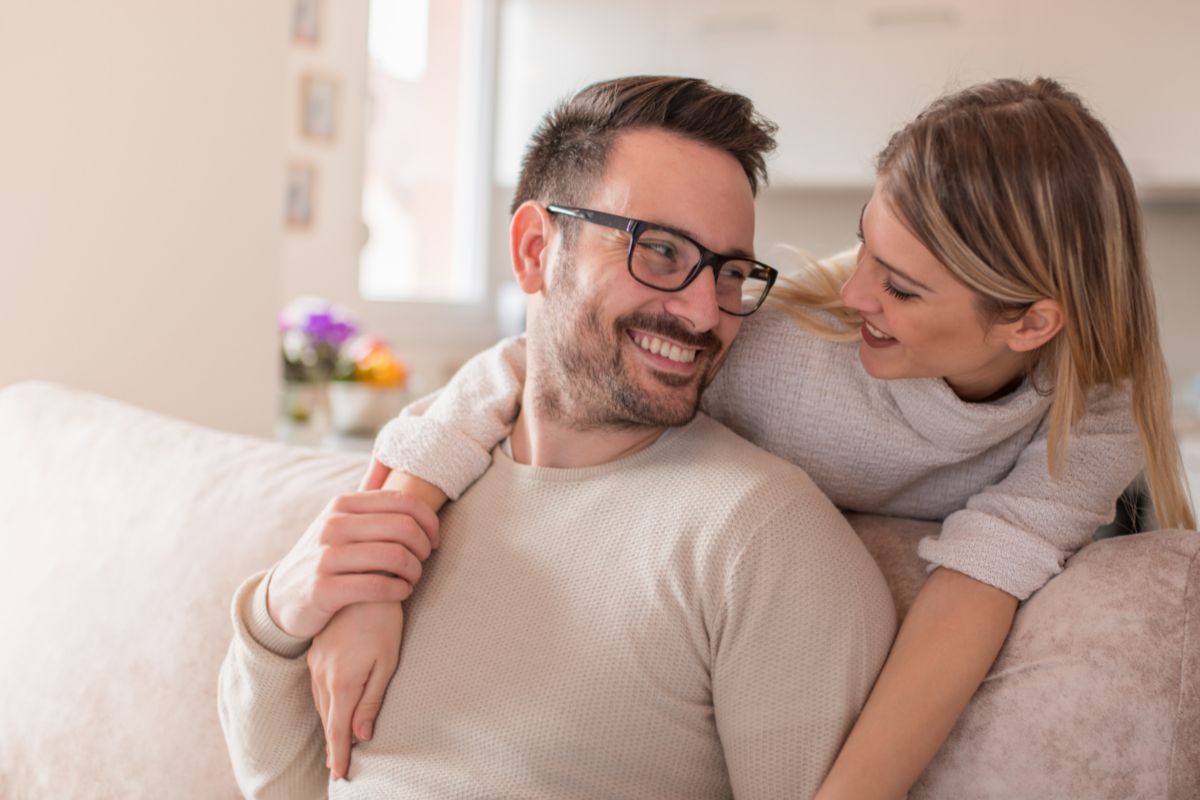 Pareja feliz sentada en el sofa