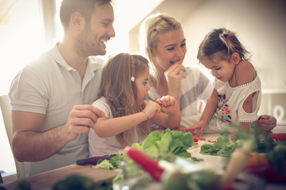 Padres con sus dos hijas preparando la comida